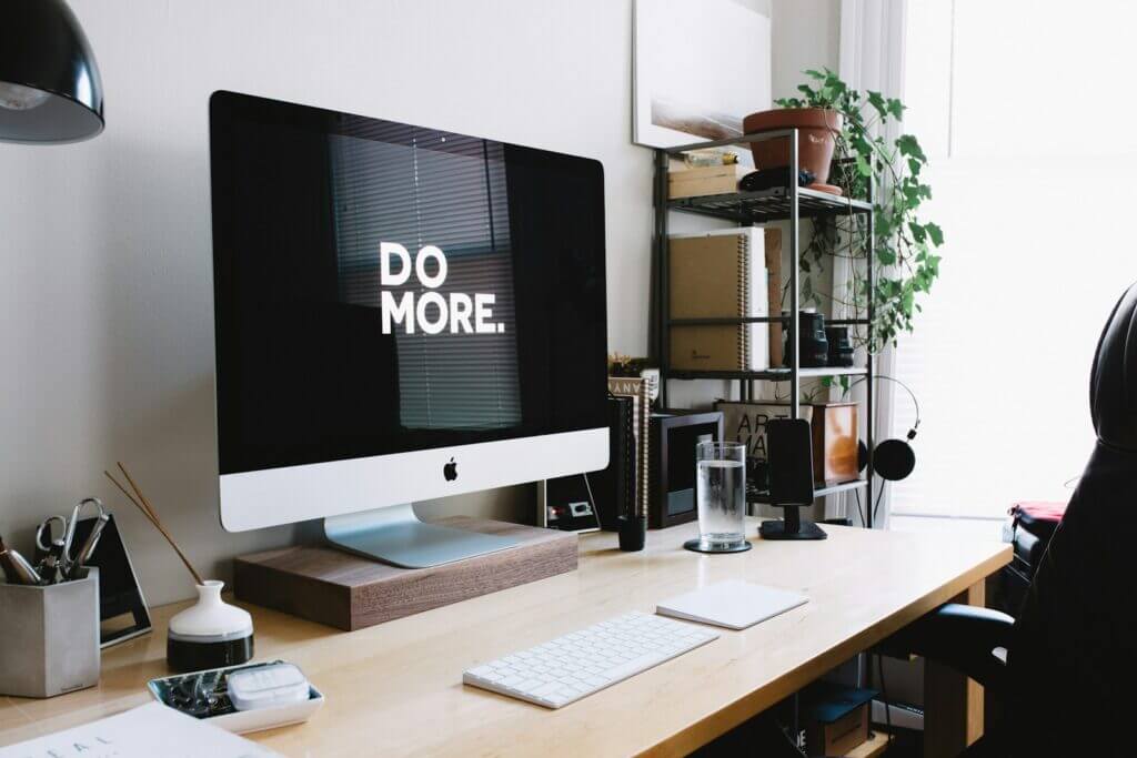 Silver imac with keyboard and trackpad inside room